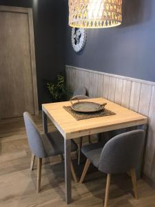 a wooden table with chairs and a plate on it at Apartament Neret II in Sort