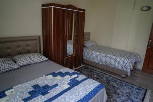 a bedroom with two beds and a dresser at Gumul pansiyon in Uzungöl
