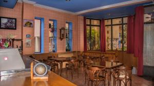 a restaurant with tables and chairs and windows at Hotel A Nieu in Jaca