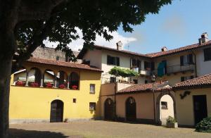 a large yellow building with balconies and a courtyard at Artdeco in Lecco