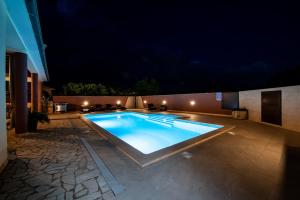 a swimming pool in a backyard at night at Villa Komel with Pool in Fažana