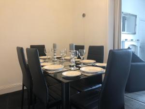 einen Esstisch mit Stühlen und Weingläsern in der Unterkunft Wellesley Apartment in Leven-Fife