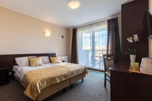 a hotel room with a bed and a window at Willa Grawit in Władysławowo