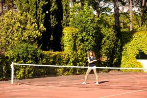 a woman standing on a tennis court holding a racket at Hotel Continental Ischia in Ischia