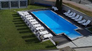 an overhead view of a swimming pool with white lounge chairs and a swimming poolretched at Eurybia in Łeba