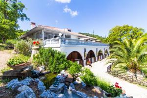 a home with a pond in front of a house at Residence Oasis in Campiglia Marittima