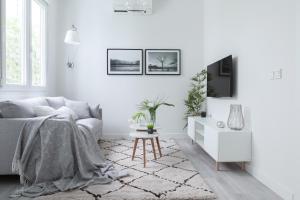 a white living room with a couch and a table at Chic Moraza by Chic Donosti in Donostia-San Sebastián