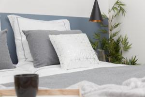 a white couch with grey pillows in a bedroom at Chic Moraza by Chic Donosti in Donostia-San Sebastián