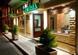 a store with potted trees in front of a building at Hotel Nevada Kalamata in Kalamata