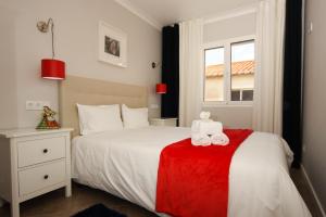 - une chambre avec un lit blanc et une couverture rouge dans l'établissement Ferhouse Dreams-Farilhões, à Nazaré