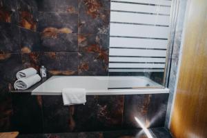 a bathroom with a bath tub and a window at Penzion Veza in Kremnica