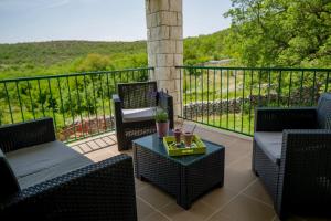 a patio with two chairs and a table on a balcony at House Lucia in Brštanovo