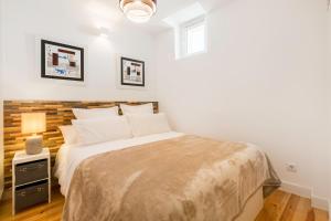 リスボンにあるSantana Apartment by Sublime Housesのベッドルーム1室(木製ヘッドボード付きのベッド1台付)