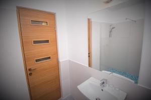 a bathroom with a sink and a wooden door at EfoRooms - Apartamente si Camere moderne in Eforie Nord +72 photos