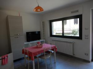 un comedor con una mesa rosa y una ventana en casa vacanze lucianoandson en Campobasso