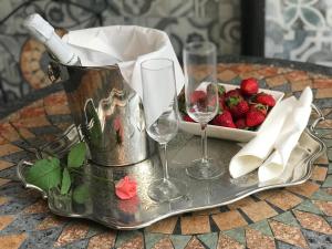 a table with two wine glasses and a bowl of strawberries at Artdeco in Lecco