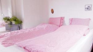 Cama rosa y blanca en habitación blanca en Flugumýri 2, en Varmahlid