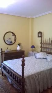 - une chambre avec un grand lit et un miroir dans l'établissement Habitacion Privada en Piso Familiar, à Pontevedra