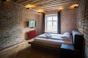 um quarto com uma cama numa parede de tijolos em Vysoka Khata1 em Lviv