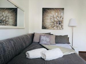 a gray couch in a living room with two pictures at Apartment "Mimoza 1" self check-in, self check-out in Otočac