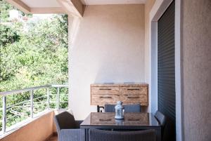 a patio with a table and chairs on a balcony at Apartment Przno in Sveti Stefan