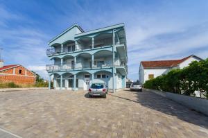 un edificio azul con un coche aparcado en un estacionamiento en Apartments Maraš, en Zadar