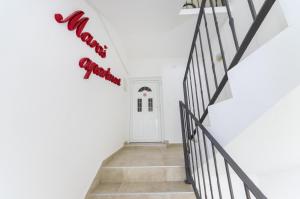 a white hallway with a white door and a sign that reads happy birthday at Apartments Maraš in Zadar