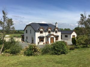uma grande casa branca com painéis solares em Tobernaglough Wexford pet friendly country b&b em Ramsgrange