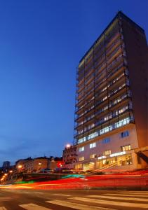 a tall building at night with a street in front of it at Hotel Neboder in Rijeka