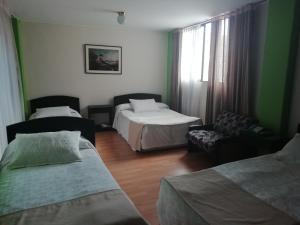 Habitación de hotel con 2 camas y sofá en Hotel Oicatá, en Duitama