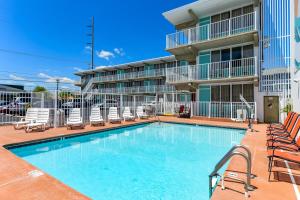 a swimming pool with chairs and a hotel at Surf Inn Suites in Ocean City