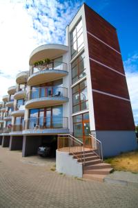 a tall building with stairs in front of it at Vienas po kitu in Šventoji