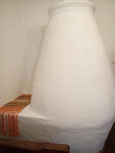 un gran jarrón blanco sentado en la parte superior de una cama en Cherry Apartman, en Abádszalók