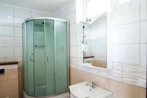 a bathroom with a glass shower and a sink at Vienas po kitu in Šventoji