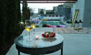 a table with two glasses of wine and a bowl of fruit at The Z Point in Parga