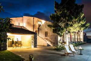 a house with two people standing in a courtyard at Ramo d'Aria Etna Boutique Hotel in Giarre