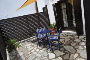 two blue chairs and a table on a patio at Hotel Hagiati in Chorefto