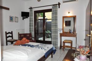 sypialnia z łóżkiem, stołem i lustrem w obiekcie Hotel Hagiati w mieście Chorefto