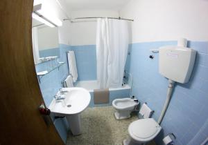bagno blu con servizi igienici e lavandino di Residencial Sol a Portimão