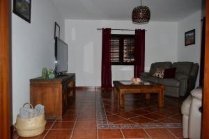 sala de estar con sofá y TV en Villa Gabriela, en Tinguatón