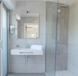 a bathroom with a sink and a shower at Hotel La Voile in Bormes-les-Mimosas