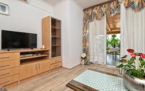 a living room with a tv and a large window at Tea Two Apartman in Neum