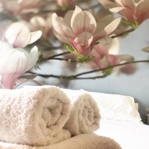 a pile of towels sitting on a bed with flowers at Boutique Apartment Volos in Volos