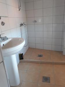 ein weißes Bad mit einem Waschbecken und einer Dusche in der Unterkunft "Park" in Visoko