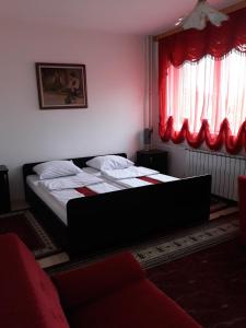 Schlafzimmer mit einem Bett und einem roten Fenster in der Unterkunft "Park" in Visoko
