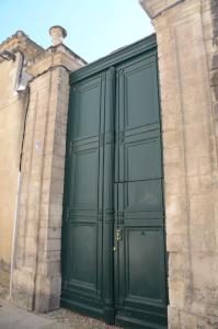 een grote groene deur aan de zijkant van een gebouw bij calme et charme in Avignon