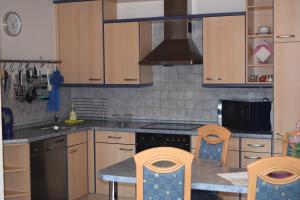 a kitchen with wooden cabinets and a stove top oven at Ferienwohnung Wandelt in Essen