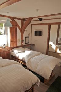 two beds in a room with wooden beams at Birchwood Guest Lodge in Balmaha