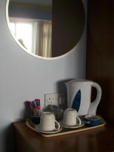 a shelf with two tea cups and a mirror at Seashore Lodge Guesthouse in Galway