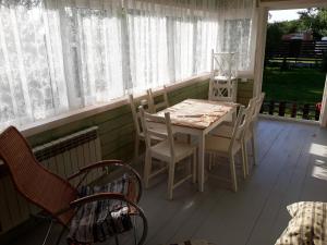 a white table and chairs on a screened in porch at Vacation home in Konstantinovo in Konstantinovo